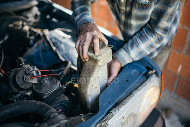 Old man working on vintage car in his garage at home — Stock Photo