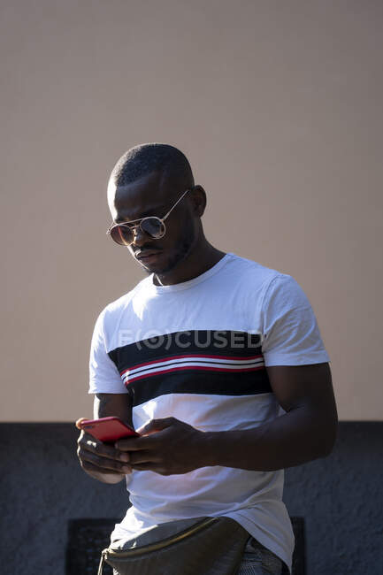 Человек в солнечных очках с помощью мобильного телефона. — стоковое фото