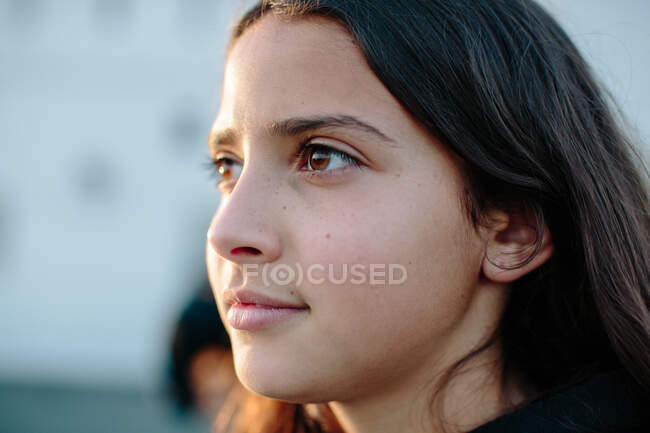 Close up perfil de uma menina de doze anos ao meio iluminado pelo sol — Fotografia de Stock