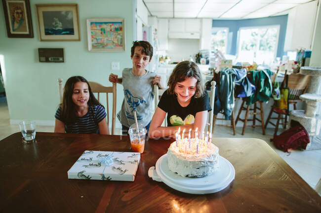 Frères et sœurs chantent joyeux anniversaire à une sœur adolescente — Photo de stock