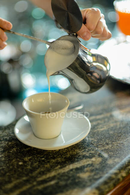 Hände junger erwachsener Barista bei der Zubereitung von Cappuccino — Stockfoto