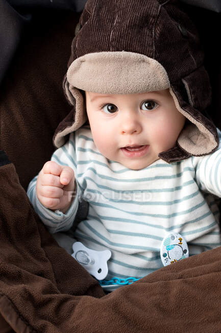 He's about a year old, very handsome, sitting in his stroller and he's wearing an aviator's hat and he's clenching his fist — Stock Photo