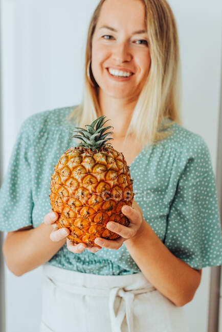Porträt einer schönen jungen Frau, die mit Ananas posiert — Stockfoto