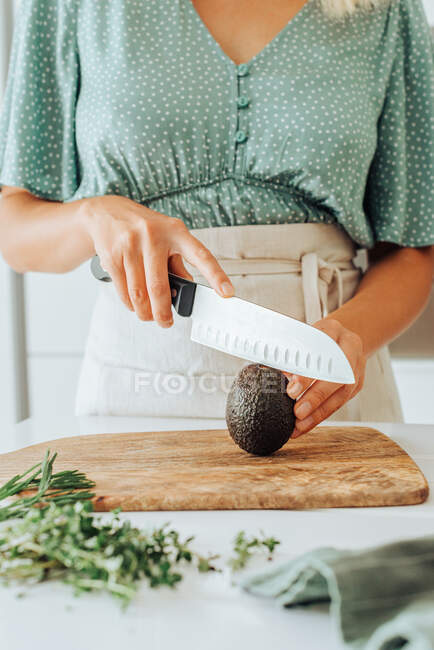 Cropped shot of woman preparing avocado for eating — Stock Photo