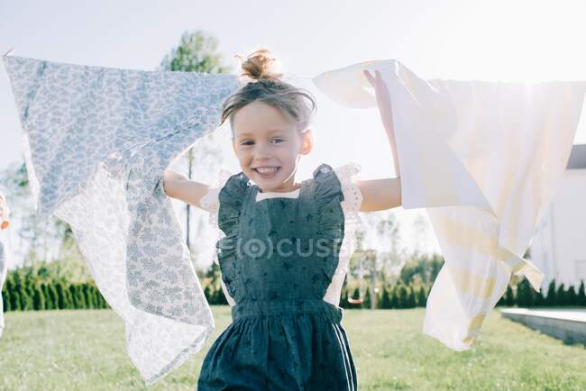 Cute girl   having fun with laundry outdoors — Stock Photo