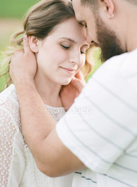 Un hombre sosteniendo a su esposa amorosamente - foto de stock