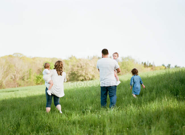 Retrato de una familia de cinco en un campo - foto de stock