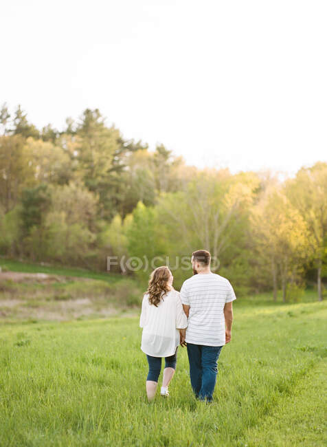 Portrait of a couple in a field close to sunset — Stock Photo