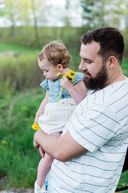 Una foto de estilo de vida del joven padre milenario con su hija - foto de stock