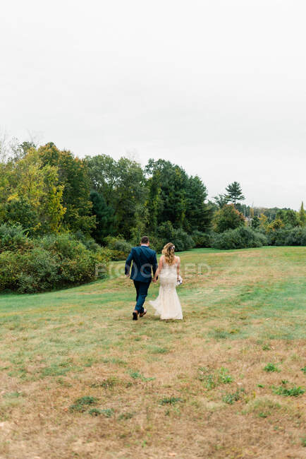 Retrato de um marido e mulher recém-casados correndo — Fotografia de Stock