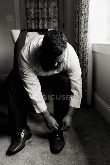 Portrait of a man putting on his dress shoes — Stock Photo