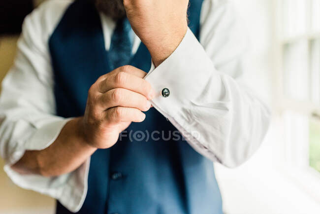 Retrato de um homem de terno se preparando, consertando seu punho — Fotografia de Stock