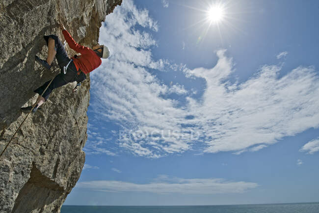 Donna che si arrampica sulla scogliera calcarea vicino alla costa di Swanage / Regno Unito — Foto stock