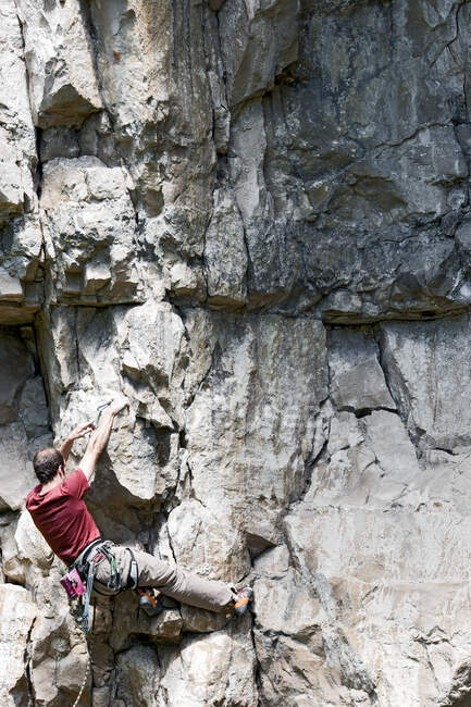 Mann klettert Kalksteinfelswand in Swanage / UK — Stockfoto
