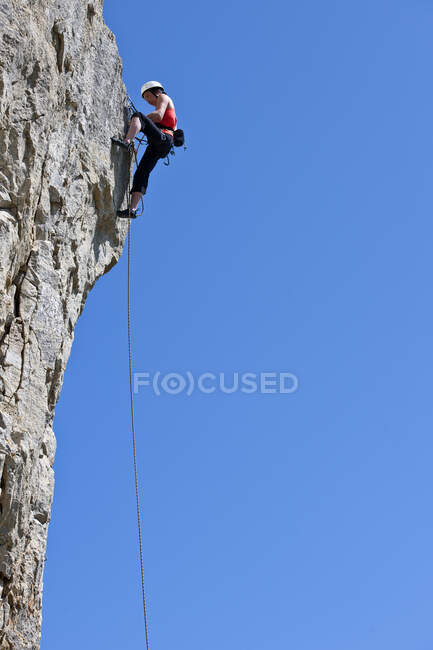 Frau klettert Kalksteinfelswand in Swanage / UK — Stockfoto