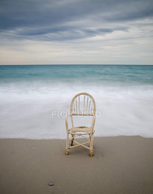 Lonely chair in the dawn of a cloudy day — Stock Photo