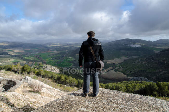 Hombre observando el horizonte desde la montaña - foto de stock