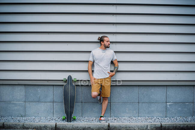 Молодой красивый мужчина со скейтбордом на открытом воздухе — стоковое фото