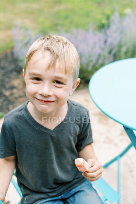 Menino desfrutando seu picolé lá fora no pátio — Fotografia de Stock