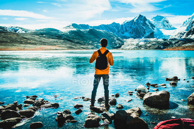 Uomo in piedi su una montagna di neve coperta lago — Foto stock