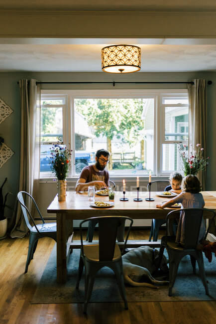 Uma jovem família desfrutando de um jantar junto com seu pesto caseiro — Fotografia de Stock