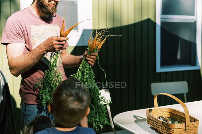 Una famiglia che lava i propri prodotti dall'orto — Foto stock
