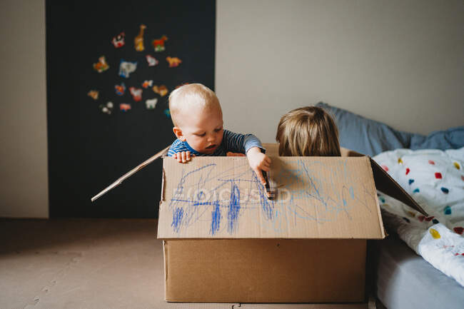 Kinder spielen und zeichnen während der Sperrung in einer Kiste — Stockfoto
