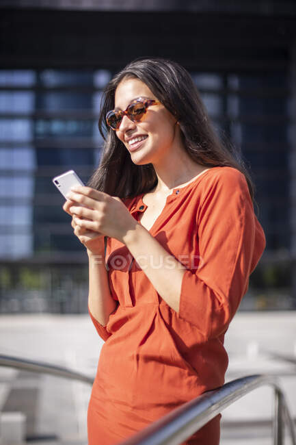Jovem sorrindo mulher bonita ler mensagens no telefone móvel — Fotografia de Stock