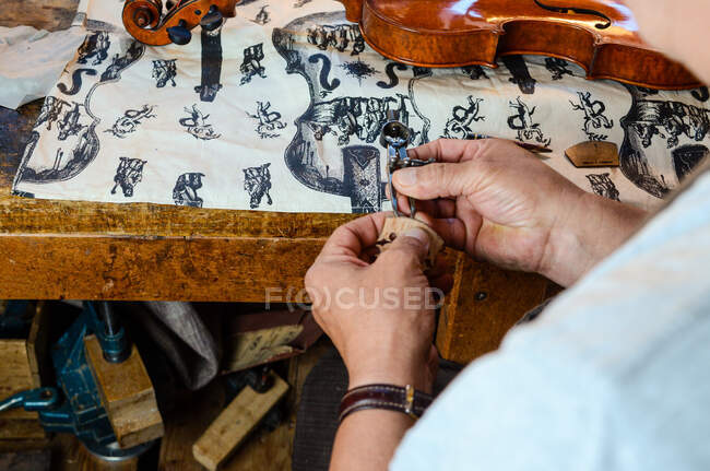 Violin maker luthier changing bridge of a handmade baroque violin — Stock Photo