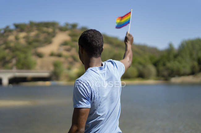 Joven con su bandera de orgullo gay - foto de stock