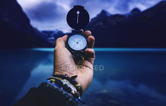 Путешественник держит компас в руке — стоковое фото