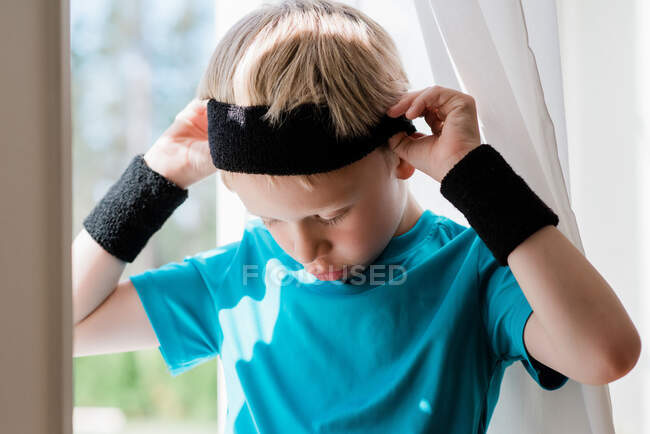 Мальчик с потными повязками на голове готов к занятиям спортом — стоковое фото