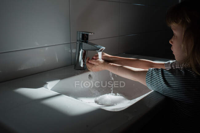 Jeune enfant se lave les mains à la maison — Photo de stock