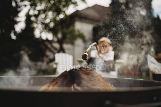 Vista frontal de marshmallow queimado para fazer smores com criança na parte de trás — Fotografia de Stock