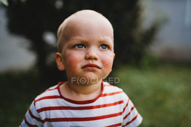 Front view portrait of young boy with serious and dirty face outdoors — Stock Photo