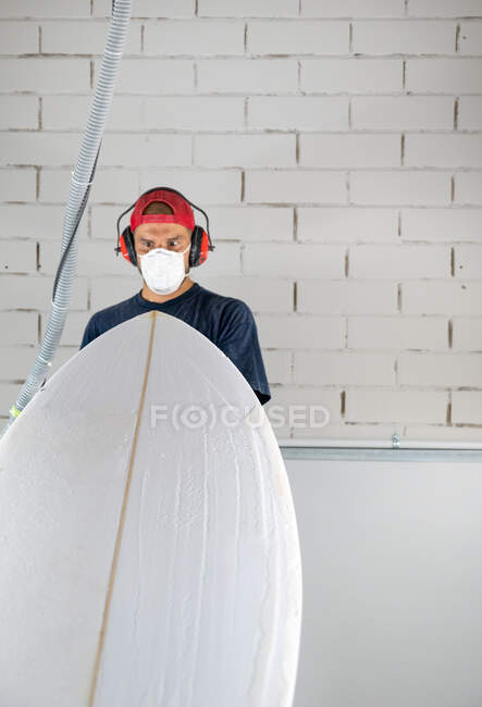 Surfboard shaper workshop - man checking quality of surfboard — Stock Photo