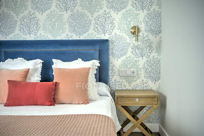 Красивые роскошные подушки на кровати, интерьер комнаты — стоковое фото