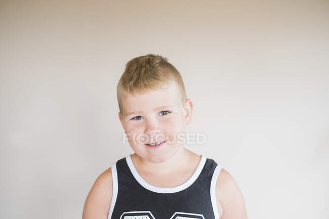 Porträt eines kleinen Jungen, der sitzt und in die Kamera blickt — Stockfoto