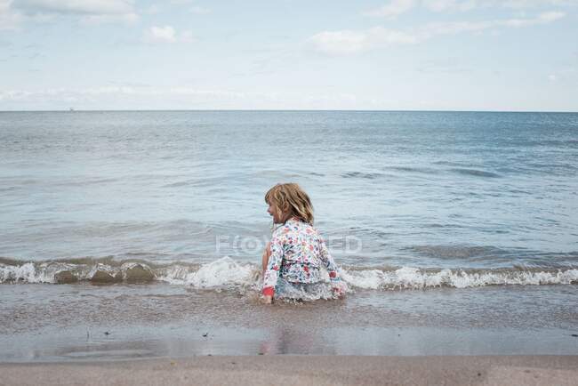 Mädchen spielt im Wasser am Strand und hat Spaß — Stockfoto