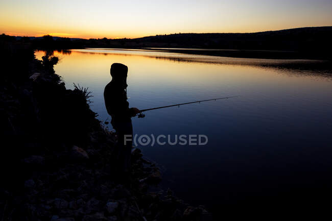 Pesca ao pôr do sol perto do mar . — Fotografia de Stock