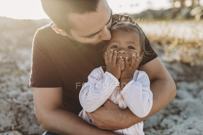 Hija y padre joven divirtiéndose en la playa - foto de stock