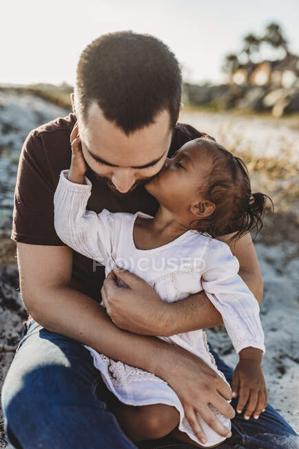 Hija y padre joven divirtiéndose en la playa - foto de stock