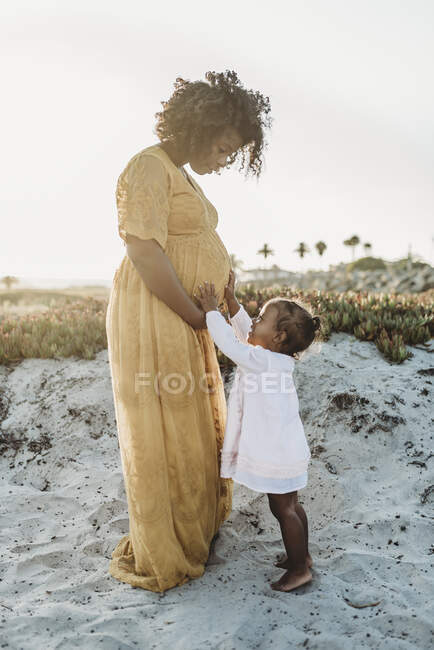 Madre e hija divirtiéndose junto al océano - foto de stock