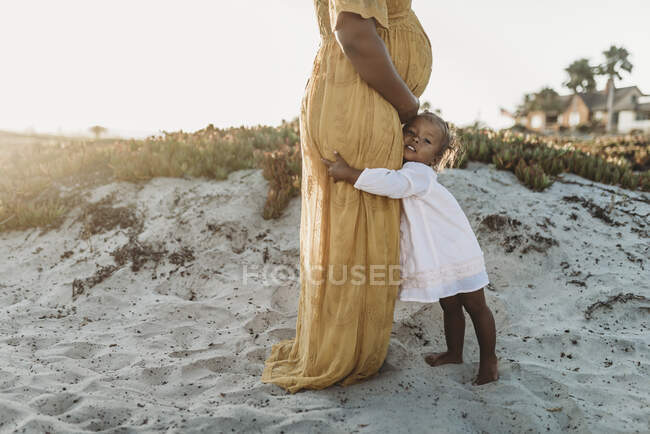 Madre e hija divirtiéndose junto al océano - foto de stock