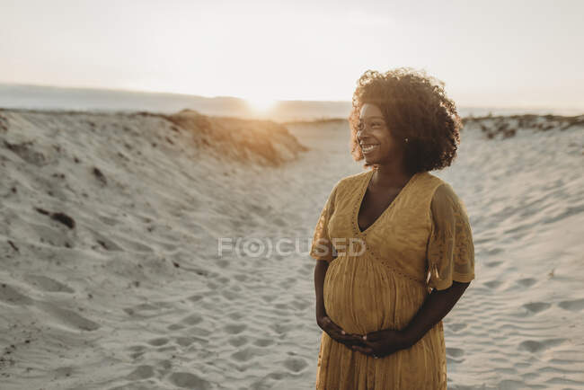 Красива молода вагітна жінка позує на пляжі — стокове фото