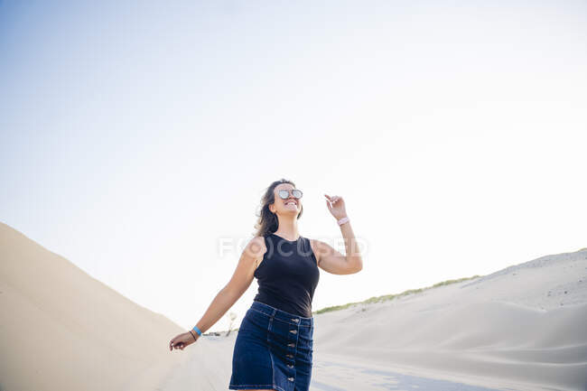 Mujer joven caminando por las dunas - foto de stock