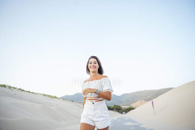 Junge Frau spaziert entlang der Dünen — Stockfoto