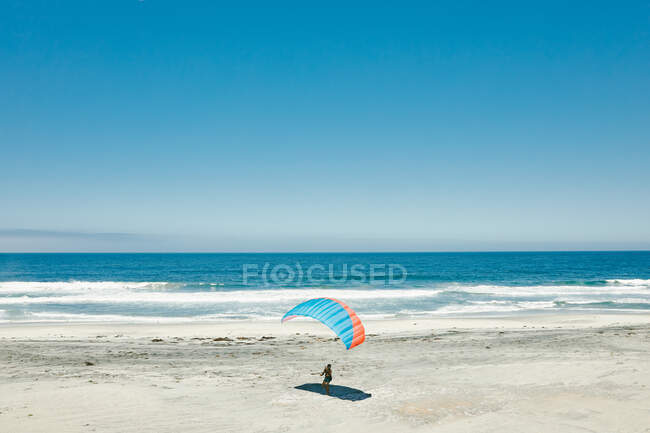 Giovanotto in parapendio sulla spiaggia della Costa Paciifc a Baja, Messico. — Foto stock