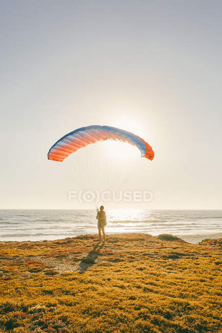 Young man paragliding during sunset over cliffs in Baja, Mexico. — Stock Photo