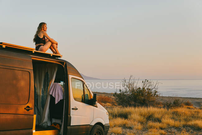 Young woman on camper van looking out to the sunrise in Baja, Mexico — Stock Photo